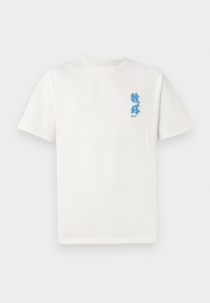 Bela bombažna majica s kratkimi rokavi. Ima moder grafični dizajn na levi strani prsnega koša, besedilo pod njim in klasičen kroj ovratnika.