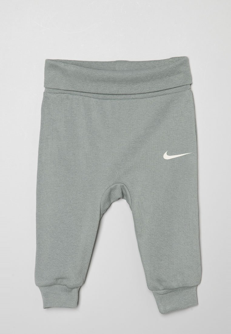 Pantalons de survêtement gris pour enfants avec une finition texturée, une taille élastique et des poignets ajustés. Comprend un logo Nike blanc sur la jambe gauche.