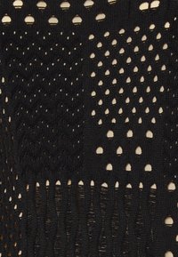 Tessuto in maglia all'uncinetto nero che presenta vari modelli e trame aperte, inclusi forme a diamante e a goccia, con un aspetto morbido e stratificato.