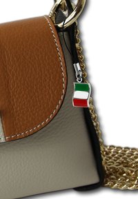 Sac en cuir marron et beige avec une chaîne en or, doté d'un petit charme en forme de drapeau italien sur une boucle en tissu noir. Texture lisse et forme structurée.