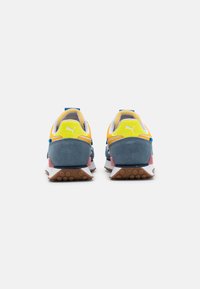 Sportliche Schuhe mit einem blauen Wildleder-Obermaterial, gelben und orangefarbenen Akzenten, weißem Netzgewebe und einer pinken Ferseneinfassung. Sie verfügen über eine strukturierte Gummisohle.