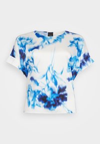 Kortermet bluse i hvit sateng med blå tie-dye mønster. Har rund hals og avslappet passform med subtile volanger på ermene.