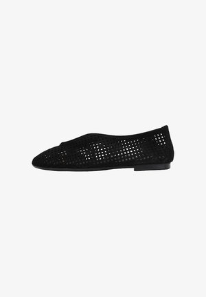 Zapato plano negro con diseño perforado y punta puntiaguda, cuenta con tacón bajo y estilo sin cordones.