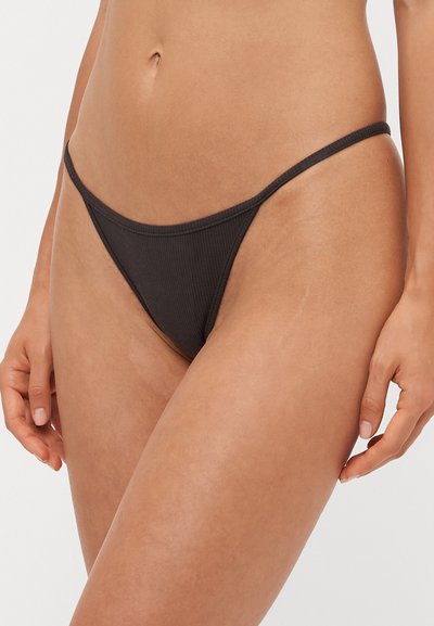 Slip bikini nera a costine con strap sottili e design minimalista, che mette in risalto un taglio a vita bassa e bordi senza cuciture per il massimo comfort.