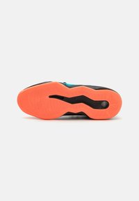 Schwarze Sportschuhsohle mit strukturiertem Muster, die einen leuchtend orangen Abschnitt aufweist. Enthält eine verlängerte Rille für Flexibilität.