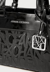 Borsa nera con logo "ARMANI EXCHANGE" in rilievo, texture lucida, forma strutturata, dotata di un'etichetta metallica e manici resistenti.