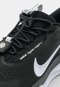 Crne Nike Pegasus tenisice imaju teksturirani mrežasti gornji dio, reflektirajuće detalje i podesive vezice s karakterističnim bijelim swoosh logom.