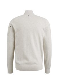 Hellgrauer Strickpullover mit hohem Kragen, langen Ärmeln und einer seitlichen aufgesetzten Tasche. Texturiertes, weiches Material mit minimalen Details.