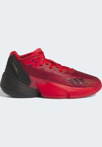 Zapatilla deportiva roja con una parte superior texturizada, acentos en el tacón negros, cordones y tres franjas en el costado. Marca destacada en el talón.