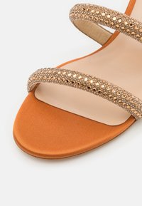 Oranžové saténové sandály s dvěma třpytivými zlatými pásky s vkládanými rhinestones, plochou podrážkou a hladkým, nahým stélkou.
