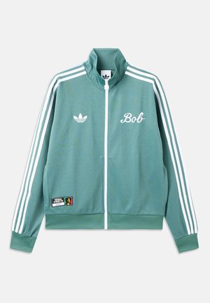 Πράσινο αθλητικό μπουφάν Adidas με λευκές ρίγες στα μανίκια, φερμουάρ στο μπροστινό μέρος, κείμενο «Bob» στο στήθος και ένα μικρό πολύχρωμο λάστιχο στο κάτω μέρος.