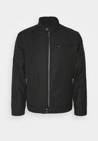 Schwarze gesteppte Steppjacke mit hohem Kragen, durchgehendem Reißverschluss, seitlichen Taschen und gesteppter Schulterpartie. Entworfen für Wärme und Komfort.