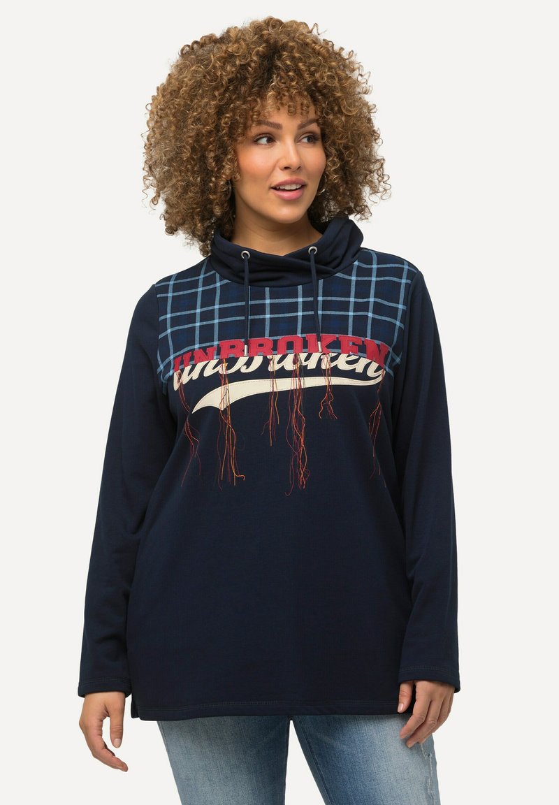 Hoodie a maniche lunghe blu navy con collo a cowl, caratterizzato da un design a quadri su un lato e stampa del testo "UNBROKEN" con accenti colorati.