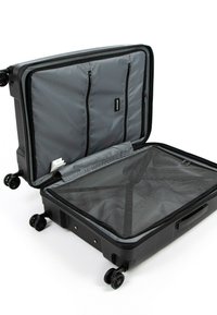 Hard-shell suitcase, black exterior, gray fabric interior, dual zippered compartments, mesh divider, four swivel wheels for mobility.