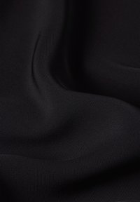 Schwarzer Stoff mit einer glatten Textur, der ein feines Rillenmuster aufweist und einen weichen Fall hat, geeignet für verschiedene Anwendungen.