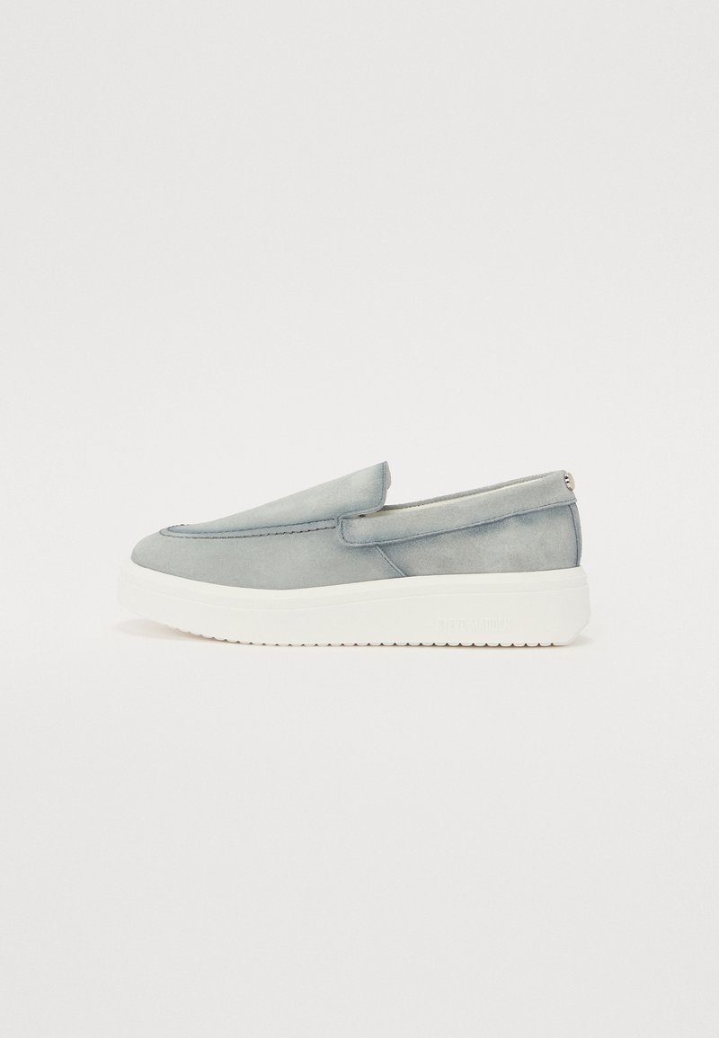 Chaussures à enfiler en daim gris clair avec une semelle en caoutchouc blanche. Présentent un design minimaliste et des détails cousus le long du devant.