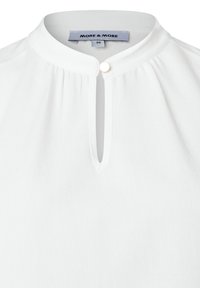White blouse with a round, collarless neckline, featuring a vertical slit and a small gold button detail at the front. Soft, lightweight fabric.