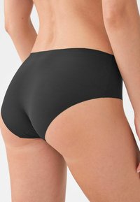 Zwarte naadloze bikini-stijl onderbroek met een gladde textuur, lage taille en minimale bedekking, met schone randen en geen zichtbare naden.