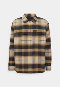 Károvaná bunda v žlutých, černých a modrých tónech, vyrobená z texturovaného materiálu. Obsahuje zip vpředu, dvě náprsní kapsy a límec.