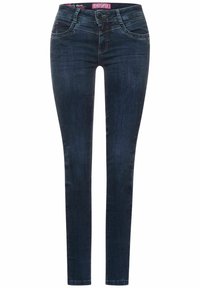 Slim jeans i mörkblå denim. Har en midjehöjd som sitter mitt emellan, subtila sömmar och nitar på framlapparna. Slät yta genom hela byxan.