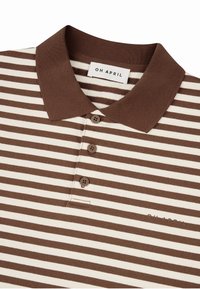 Brūnas un krēmkrāsas svītrainas polo krekls no adītas auduma, ar apkakli, trīs pogu atloku un zīmola etiķeti uz apkakles.