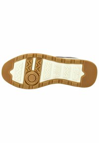 Bílé gumové podrážky s texturovanou hnědou gumovou mezipodpěrnou vrstvou. Obsahuje cikcakové a horizontální vzory. Centrální disk označený "TRVL LITE."