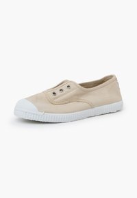 Sneaker di tela beige con punta e suola in gomma bianca. Presenta occhielli in metallo per i lacci e dettagli cuciti sul materiale superiore.
