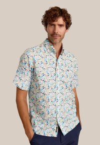 Korte mouwen overhemd met knopen, met een witte basis en een kleurrijk bladerenpatroon in groen, oranje en blauw. Gemaakt van lichtgewicht stof.