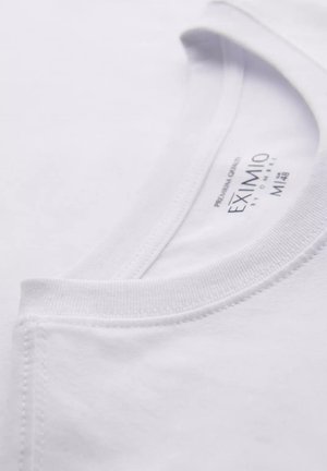 Weißes Baumwoll-T-Shirt mit Rundhalsausschnitt, glatter Textur und dezenten Nähdetails. Etikett im Kragen bedruckt.
