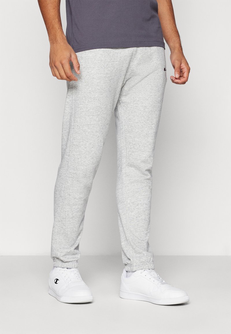 Pantaloni sportivi gri din material moale, având mansete elastice și o croială confortabilă. Asociați cu adidași albi.