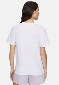 T-shirt bianco in cotone con collo a giroclassico e maniche corte, mostrato da dietro. Design semplice, senza motivi o dettagli visibili.