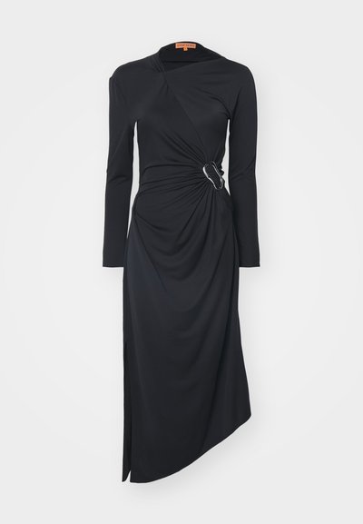 Vestido negro de manga larga en tejido suave, con un diseño retorcido en la cintura y un acento de hebilla plateada, con una abertura lateral para añadir detalle.