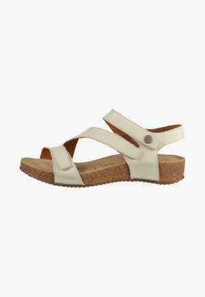 Beige lædersandal med to krydsende stropper, justerbar Velcro-lukning, korksål og struktureret gummisål for godt greb.