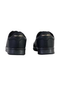 Black athletic shoes featuring a smooth leather upper, padded collar, flat rubber sole, and gold embossed logo on the heel.