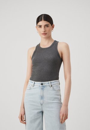 Gray fitted tank top made of ribbed fabric with a round neckline, paired with light blue high-waisted jeans.