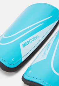 Turquoise football shin guards with a glossy finish, featuring white accents and the brand name "MERCURIAL." Left and right markings included.