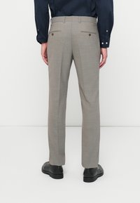 Ανατομικό γκρι παντελόνι με διακριτό καρό σχέδιο, που διαθέτει δύο πίσω τσέπες με κουμπιά και λεία υφή.