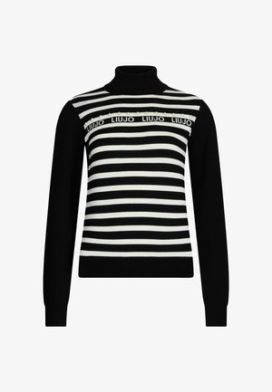 Suéter de cuello alto a rayas blanco y negro con textura acanalada y rayas horizontales, que presenta una banda con logo y cuentas decorativas en el pecho.