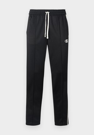 Schwarze Sporthose mit weißem Kordelzug, seitlichen Streifen, Vordertaschen und einem kleinen weißen Champion-Logo auf dem linken Oberschenkel.