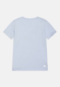 T-shirt en coton bleu clair, à manches courtes, col rond, avec une petite impression blanche "ULTRA DRY" dans le coin inférieur droit. Texture lisse.