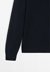Marineblauer gestrickter Pullover mit glatter Textur, langen Ärmeln und rundem Halsausschnitt. Die Bündchen und der Saum sind gerippt für zusätzliche Strapazierfähigkeit.