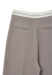 Pantalons cintrés couleur brun clair avec une finition texturée, dotés d'une taille blanche et de deux poches arrière. Vue arrière, lignes épurées.