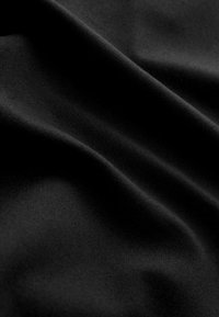 Tessuto nero con una texture liscia e morbida, caratterizzato da pieghe sottili e un colore uniforme privo di motivi o decorazioni.
