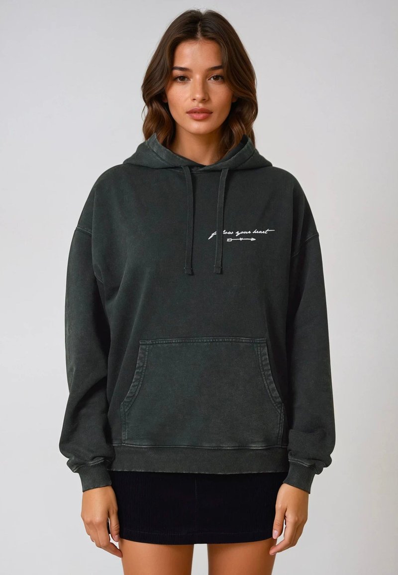 Felpa oversize verde scuro con tasca frontale e testo stampato bianco. Materiale in cotone morbido e polsini e orlo a costine.