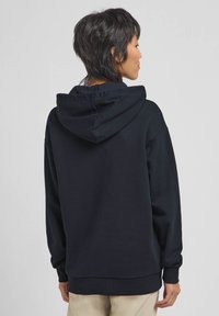 Felpa nera con cappuccio regolabile, maniche lunghe e vestibilità comoda. Tessuto spesso e liscio con polsini e orlo a costine.