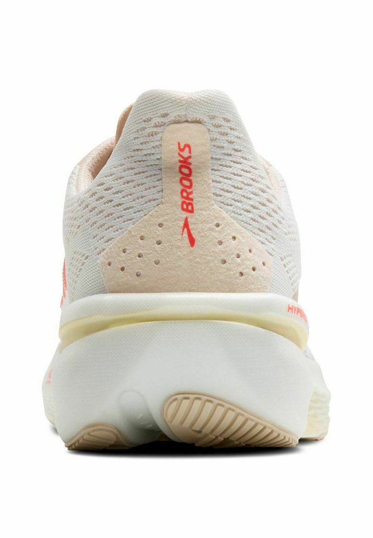 Buty biegowe Brooks z lekką siateczką w białych i brzoskwiniowych odcieniach, z teksturowaną tylną częścią, wyróżniającym się logo i amortyzowaną podeszwą.