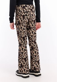 Uitgebreide broek in een meerkleurige luipaardprintstof, met een mix van beige, bruin en zwart, voorzien van achterzakken en een soepele textuur.