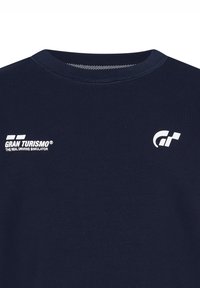 Mörkblå bomull t-shirt med rund hals; har vit "Gran Turismo"-logotyp och racing-symbol på bröstet. Slät textur, standard passform.