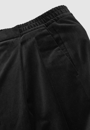 Fekete velúr nadrág elasztikus derékkal, elülső pliszékkel és sima textúrával, amely a kényelem és a szabad mozgás érdekében készült.