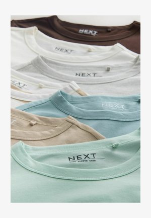Variados camisetas de manga larga y cuello redondo en beige, azul claro, blanco y marrón. Tejido suave con etiqueta de la marca visible en el interior del cuello.